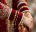 Pakistani bridal bangles — red velvet chooriyan with white pearl karas and kaleere on a bride's wrist