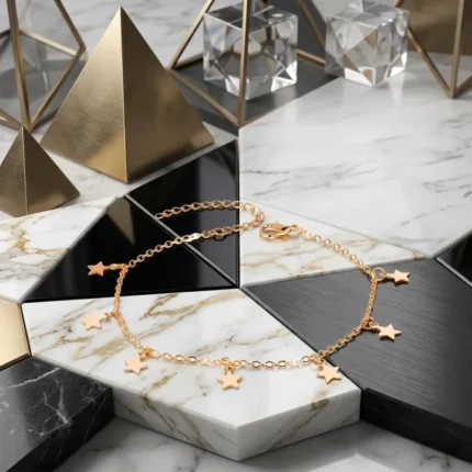 Gold star charms anklet flat lay on marble showing the star pendant design